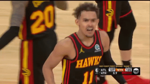 A Man In A Hawks Jersey Stands On A Basketball Court GIF