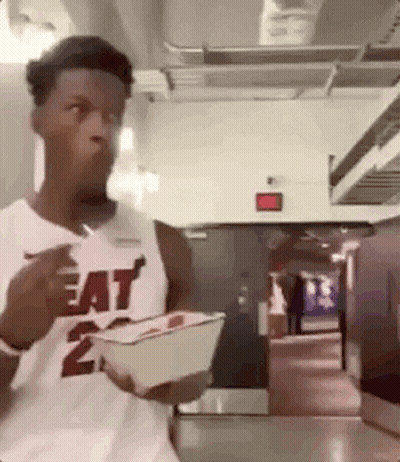 A Man In A Heat Jersey Is Eating A Meal From A Bowl . GIF