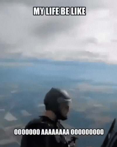 A Man In A Helmet Is Flying A Parachute In The Air . GIF
