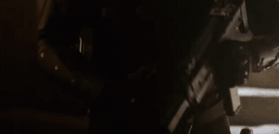 A Man In A Helmet Is Holding A Gun In His Hand . GIF