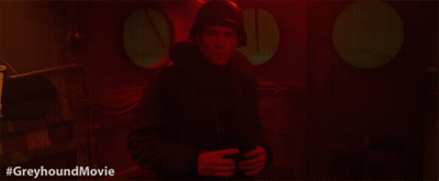 A Man In A Helmet Is Standing In A Dark Room With The Hashtag #Greyhoundmovie Below Him GIF