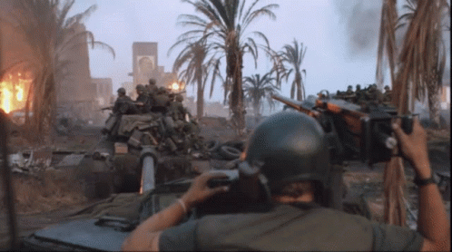 A Man In A Helmet Is Taking A Picture Of Soldiers In A Tank GIF