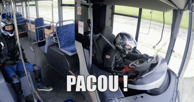 A Man In A Helmet Sits In The Driver 'S Seat Of A Bus With The Words Pacou Written On The Bottom GIF