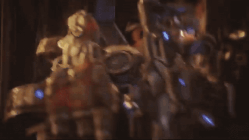 A Man In A Helmet With The Letter D On It Looks At Another Man GIF