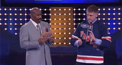 A Man In A Hockey Jersey Is Standing Next To A Man In A Suit And Tie On A Stage . GIF