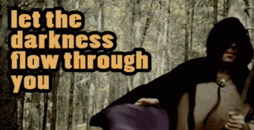 A Man In A Hooded Cape With The Words Let The Darkness Flow Through You Behind Him GIF