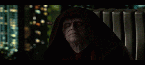 A Man In A Hooded Cloak Looks At The Camera GIF