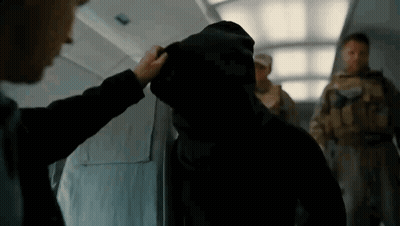 A Man In A Hooded Jacket Is Being Touched By Another Man GIF