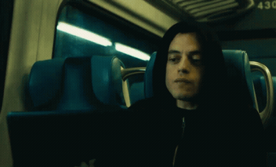 A Man In A Hooded Jacket Is Sitting In A Blue Seat With The Number 43 On The Back GIF