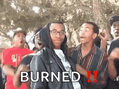 A Man In A Hooded Jacket Is Standing In Front Of A Group Of People And Says Burned . GIF