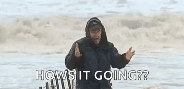 A Man In A Hooded Jacket Is Standing On A Beach And Asking How Is It Going ? GIF