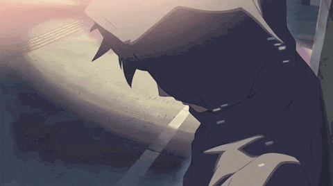 A Man In A Hooded Jacket Is Standing On A Sidewalk GIF