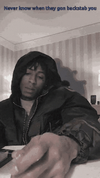 A Man In A Hooded Jacket With The Words Never Know When They Gon Backstab You On The Bottom GIF