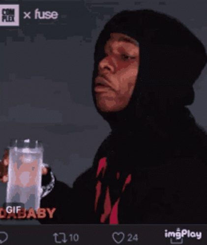 A Man In A Hoodie Holds A Glass Of Water GIF