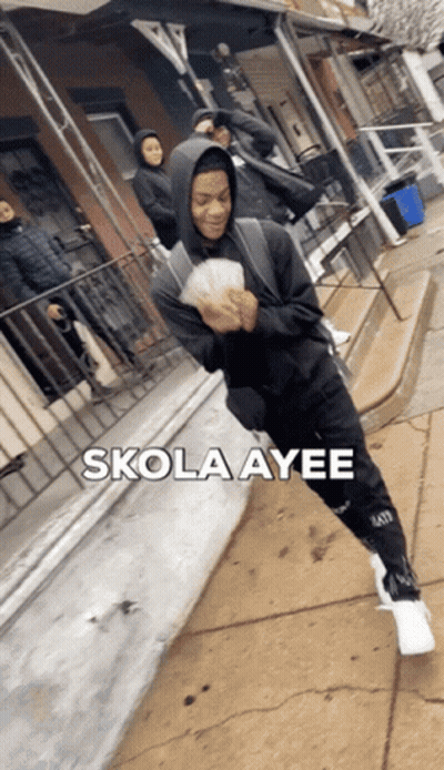 A Man In A Hoodie Is Holding A Bunch Of Money And The Words Skola Ayee Are Above Him GIF