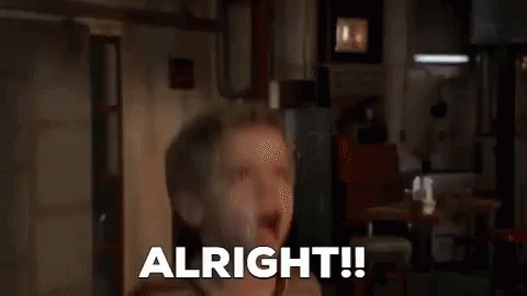 A Man In A Hoodie Is Sitting In Front Of A Window And Says `` Alright '' . GIF