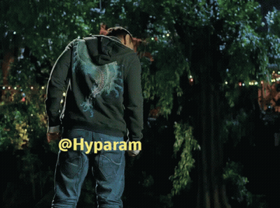 A Man In A Hoodie Is Standing In Front Of A Tree With The Word Hyparam On The Bottom Right Corner GIF