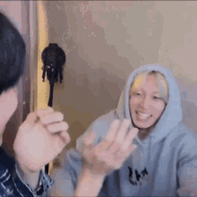 A Man In A Hoodie Is Talking To Another Man In A Room While Another Man Looks On . GIF