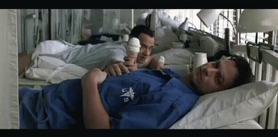 A Man In A Hospital Bed Is Wearing A Shirt That Says Us GIF