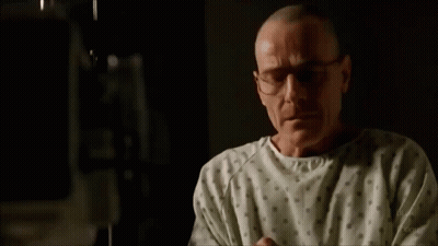 A Man In A Hospital Gown Is Crying While Sitting On A Bed . GIF