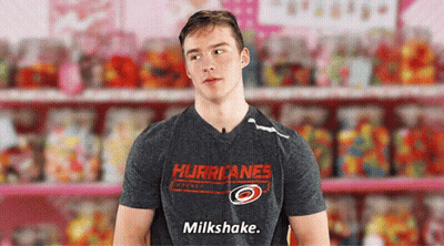 A Man In A Hurricanes Shirt Says Milkshake In Front Of Candy GIF