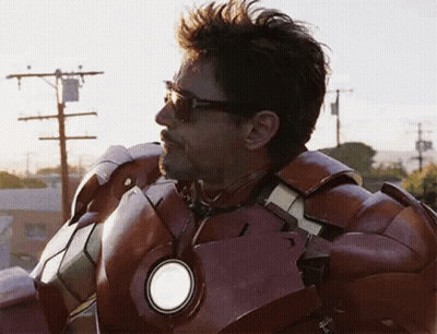 A Man In A Iron Man Suit Is Standing On Top Of A Building . GIF