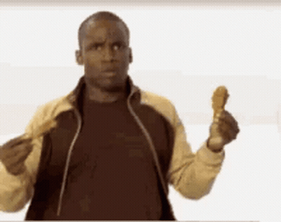 A Man In A Jacket Is Holding A Fried Chicken Wing In His Hand . GIF