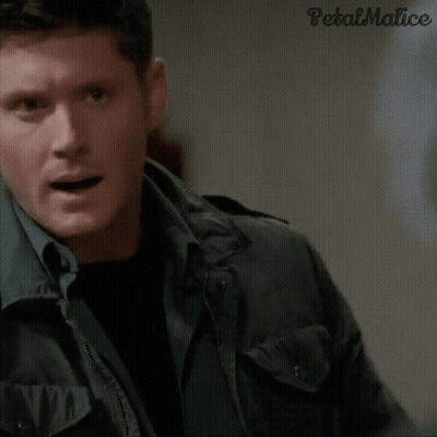A Man In A Jacket Is Holding A Necklace In His Hand . GIF