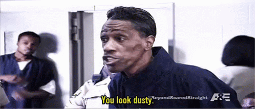 A Man In A Jail Cell Is Talking To A Police Officer And Saying You Look Dusty . GIF