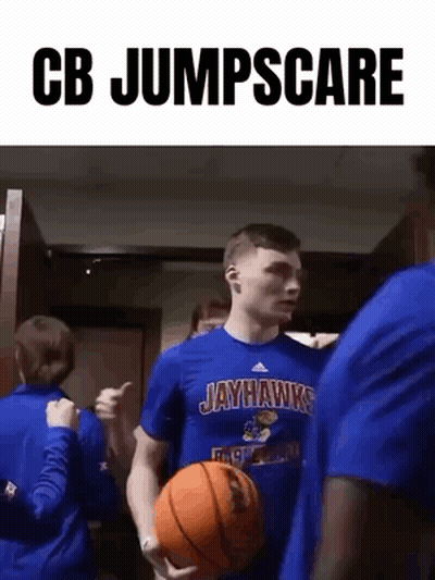 A Man In A Jayhawks Shirt Is Holding A Basketball And Giving A Thumbs Up . GIF