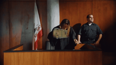 A Man In A Judge 'S Robe Is Throwing Money In A Courtroom With A California Flag In The Background GIF