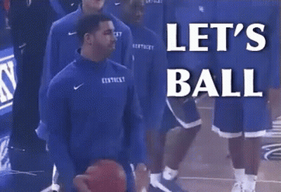A Man In A Kentucky Jersey Is Holding A Basketball In Front Of A Sign That Says Let 'S Ball GIF