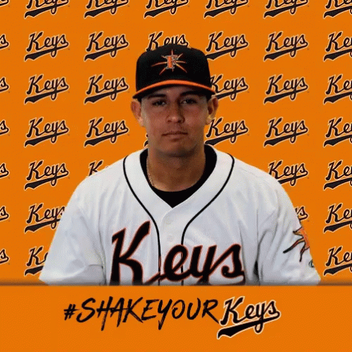 A Man In A Keys Jersey Stands In Front Of An Orange Wall GIF