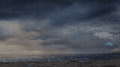 A Man In A Kilt Is Standing In Front Of A Stormy Ocean GIF