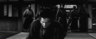 A Man In A Kimono Is Kneeling Down In Front Of A Group Of Samurai . GIF