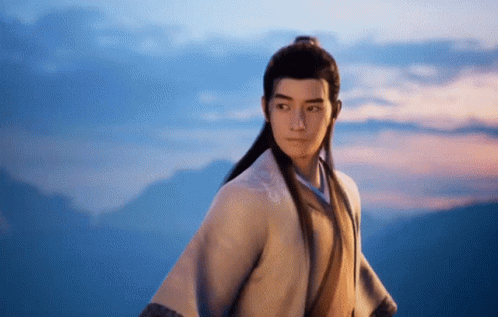 A Man In A Kimono Is Standing In Front Of Mountains GIF