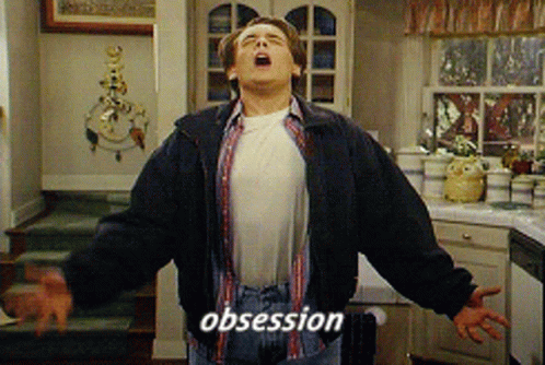 A Man In A Kitchen With His Mouth Open And The Word Obsession On His Chest GIF