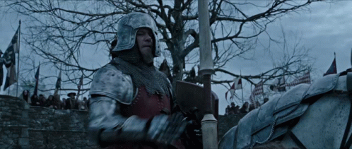 A Man In A Knight 'S Armor Is Riding A Horse In Front Of A Crowd GIF