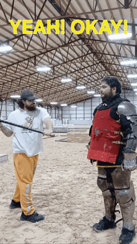 A Man In A Knight 'S Armor Is Standing Next To Another Man In A White Shirt That Says Yeah GIF