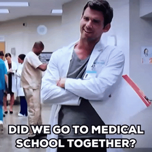 A Man In A Lab Coat Is Standing In A Hospital Hallway With His Arms Crossed And The Caption Did We Go To Medical School  GIF