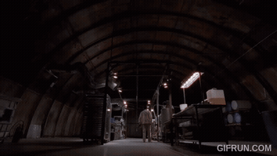 A Man In A Lab Coat Is Touching A Metal Object With The Website Gifrun.com Visible Behind Him GIF