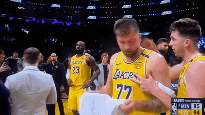 A Man In A Lakers Jersey Holds A Piece Of Paper In His Hand GIF