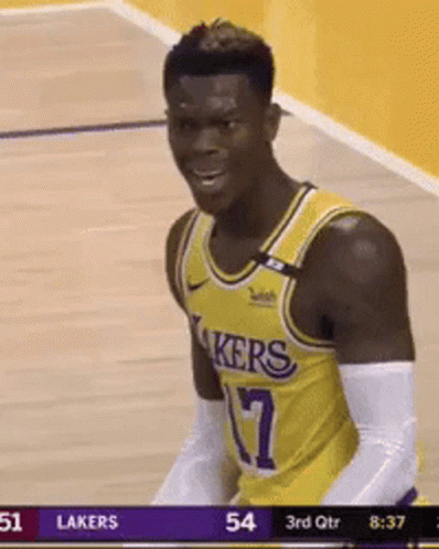 A Man In A Lakers Jersey Is Standing On A Basketball Court . GIF