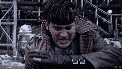 A Man In A Leather Jacket And Gloves Is Standing In The Snow With Kepler In The Corner GIF