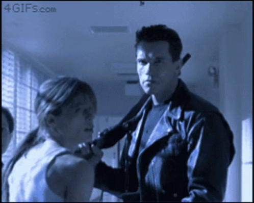 A Man In A Leather Jacket Holds A Gun To A Woman 'S Neck And Says 4Gifs.com GIF