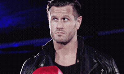 A Man In A Leather Jacket Holds A Red Boxing Glove GIF