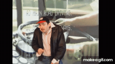 A Man In A Leather Jacket Is Dancing In Front Of A Screen That Says ' At Least Road Driving ' On It GIF
