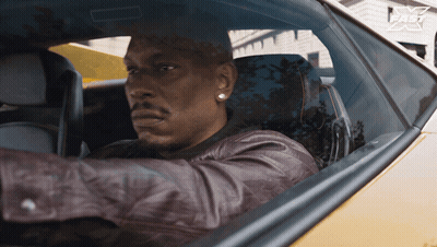 A Man In A Leather Jacket Is Driving A Car With A Fast Logo On The Side GIF