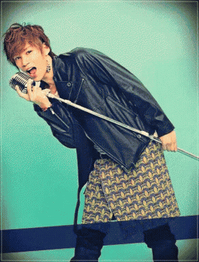 A Man In A Leather Jacket Is Holding A Microphone GIF