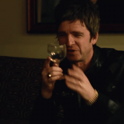 A Man In A Leather Jacket Is Holding A Wine Glass GIF